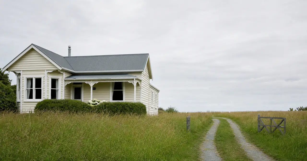 Making a house insurance claim, on a cream weatherboard cottage with dark windows.