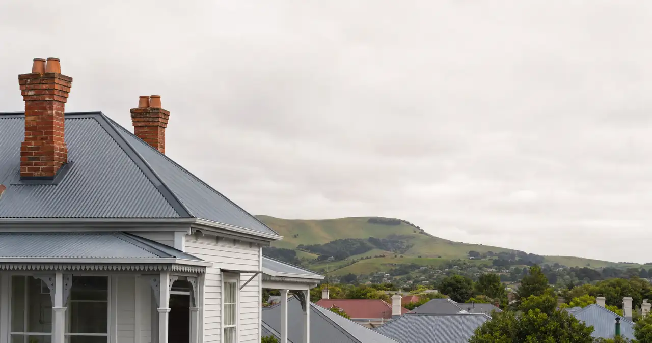 A house insurance policy wording glossary, on corrugated rooflines and brick chimneys of older New Zealand houses.